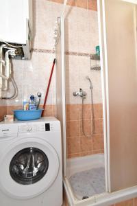 a washing machine in a bathroom with a shower at Apartman Podravina in Ludbreg