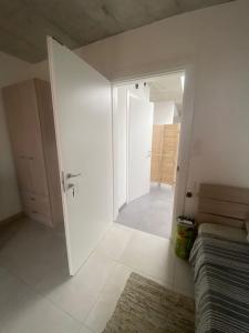 um quarto branco com uma porta que leva a um quarto em Minimal & Arty Townhouse em Hamrun