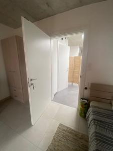een witte kamer met een deur naar een slaapkamer bij Minimal & Arty Townhouse in Hamrun
