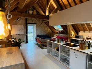 a kitchen and living room with wooden ceilings at LES BRIQUES in Lion-sur-Mer