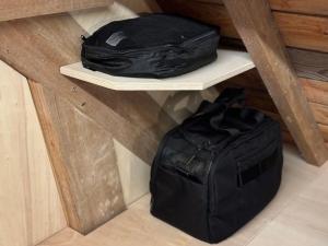 two black bags sitting on a shelf in a room at LES BRIQUES in Lion-sur-Mer