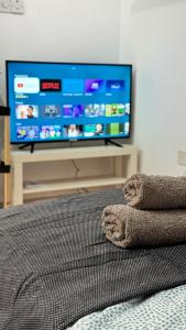 - une chambre avec une télévision à écran plat et un lit dans l'établissement PMP Adamia Apartments, à Peyia