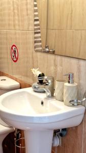 La salle de bains est pourvue d'un lavabo blanc et d'un miroir. dans l'établissement PMP Adamia Apartments, à Peyia