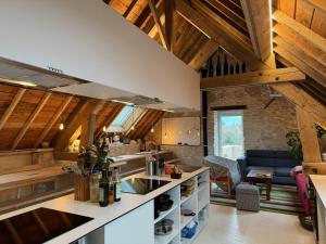 a kitchen with wooden ceilings and a living room at LES BRIQUES in Lion-sur-Mer