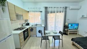 a small kitchen with a table and chairs and a stove at PMP Adamia Apartments in Peyia