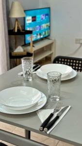 a table with white plates and silverware on it at PMP Adamia Apartments in Peyia