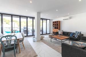 a living room with a couch and a table at BRAND NEW PENTHOUSE TERRACE BBQ WIFI MODERN MALAGA in Málaga