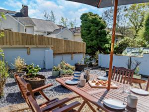 a patio with a table and chairs and an umbrella at 2 Bed in Totnes 94724 in Totnes