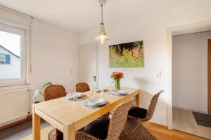 a dining room with a wooden table and chairs at Ferienwohnung Am Schlehbach in Offingen