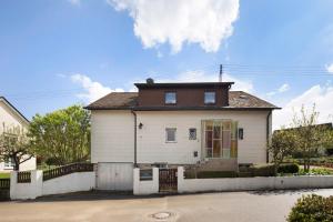 a white house with a brown roof at Ferienwohnung Am Schlehbach in Offingen