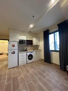 a kitchen with a white refrigerator and a stove at نمو الديار in Al ‘Azīzīyah