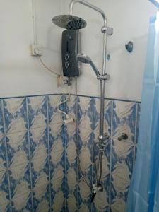 een douche met een douchekop in de badkamer bij Maliga inn in Gampola