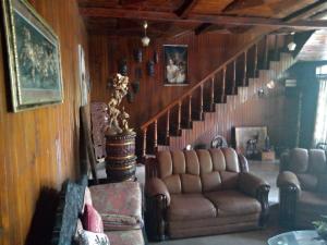 een woonkamer met een bank en een trap bij Maliga inn in Gampola