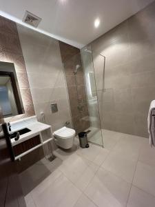 een badkamer met een douche, een toilet en een wastafel bij نمو الديار in Al ‘Azīzīyah