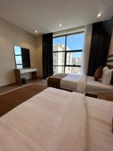 a hotel room with two beds and a large window at نمو الديار in Al ‘Azīzīyah