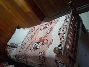 Een bed met een kattendeken erop. bij Maliga inn in Gampola