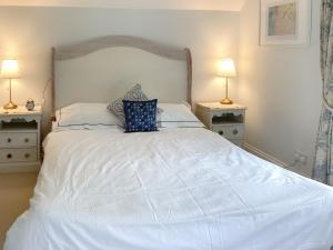 ein Schlafzimmer mit einem großen weißen Bett mit zwei Lampen in der Unterkunft 3 Bed in Bicester 94701 