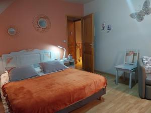 ein Schlafzimmer mit einem großen Bett mit einer orangefarbenen Decke in der Unterkunft Chambre D'hotes Le Clos Fleuri in Criel-sur-Mer