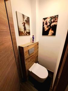 a small bathroom with a toilet and two pictures at chambre avec 2 lits séparé dans une maison l'hote in Liège