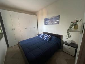 1 dormitorio con cama azul y almohada azul en La Casetta di Lia - vista mare Eden Rock, en Riva dei Pini