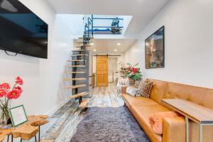 a living room with a couch and a staircase at Denver Tiny House Walk to Cafes, Bars, Eateries! in Denver