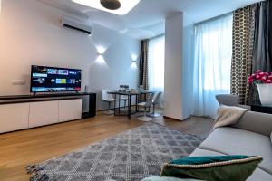 un soggiorno con divano e TV di Dream Suites Milano San Babila a Milano