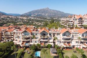 een luchtzicht op een resort met een berg op de achtergrond bij HEATED ROOFTOP POOL PENTHOUSE VIEWS MAGNA MARBELLA in Marbella