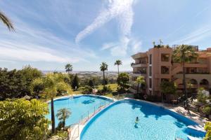 uitzicht op een groot zwembad in een resort bij HEATED ROOFTOP POOL PENTHOUSE VIEWS MAGNA MARBELLA in Marbella