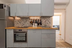 a kitchen with white cabinets and a stove top oven at U Paradise - Intero Apt - Vicino Bari in Valenzano