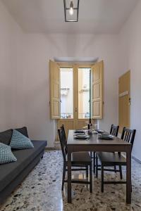a dining room with a table and chairs and a couch at U Paradise - Intero Apt - Vicino Bari in Valenzano