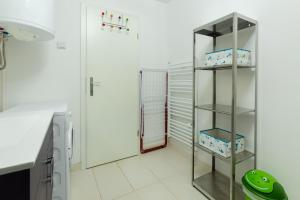 Una cocina con paredes blancas y una estantería con cajas. en Svarun apartment, en Bovec 25 fotos más