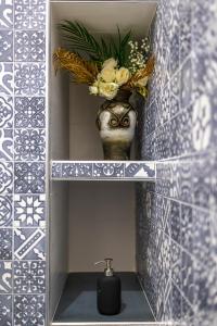 a bathroom with a sink and a vase with flowers at U Paradise - Intero Apt - Vicino Bari in Valenzano