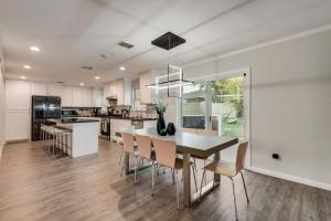 アーリントンにあるLuxury Home w Hot Tub near AT&T Stadiumのテーブルと椅子のあるキッチンとダイニングルーム