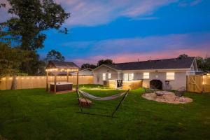 アーリントンにあるLuxury Home w Hot Tub near AT&T Stadiumの夜の庭にハンモックがある裏庭