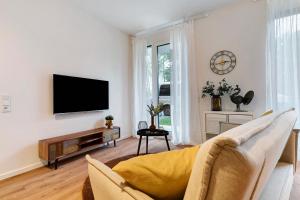 Una sala de estar con un televisor de pantalla plana en una pared. en Km Style Apartments 4, en Freiburg im Breisgau