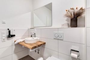 Un baño blanco con lavabo y espejo. en Km Style Apartments 4, en Freiburg im Breisgau 18 fotos más