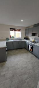 a large kitchen with white cabinets and a tile floor at Guest Village in Hull