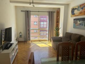 ein Wohnzimmer mit einem Sofa und einem TV in der Unterkunft Apartamento céntrico in Madrid
