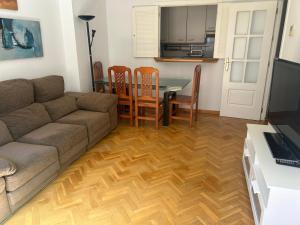 ein Wohnzimmer mit einem Sofa, einem Tisch und Stühlen in der Unterkunft Apartamento céntrico in Madrid
