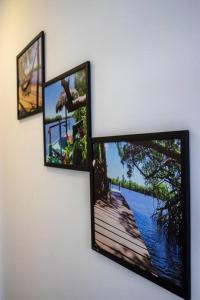 three picture frames hanging on a wall at Casa Dênora - Barreirinhas - MA - Lençóis Maranhenses in Barreirinhas