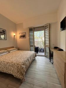 um quarto com uma cama, uma secretária e uma janela em Vacanze Romane em Lido di Ostia