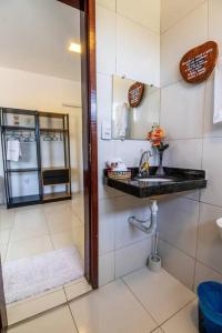 a bathroom with a sink and a mirror at Casa Dênora - Barreirinhas - MA - Lençóis Maranhenses in Barreirinhas