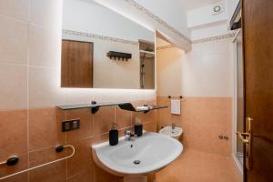 a bathroom with a sink and a mirror at Casa Rufino, Sauna e Cromoterapia in Assisi