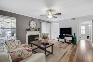 a living room with a couch and a clock on the wall at Heart of Dallas - Cozy Apt 2Bed Pool Green in Dallas