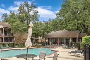 a pool with a table and a umbrella at Heart of Dallas - Cozy Apt 2Bed Pool Green in Dallas