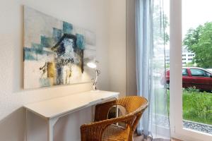 een wit bureau in een kamer met een raam bij Km Style Apartments 3 in Freiburg im Breisgau