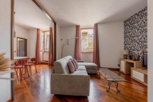 uma sala de estar com um sofá e uma mesa em CASA RUFINO con Sauna, Cromoterapia e Degustazione Vino em Assisi