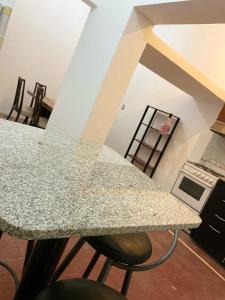une cuisine avec un comptoir et une table avec des chaises dans l'établissement Dpto Céntrico en Catamarca Capital, à San Fernando del Valle de Catamarca