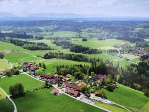 Eurasburg的住宿－Ferienwohnungen Mörzhof Eurasburg，绿色田野中小村庄的空中景观