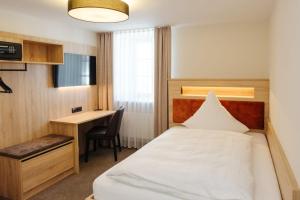 ein Hotelzimmer mit einem Bett und einem Schreibtisch in der Unterkunft Hotel Sixt in Rohr